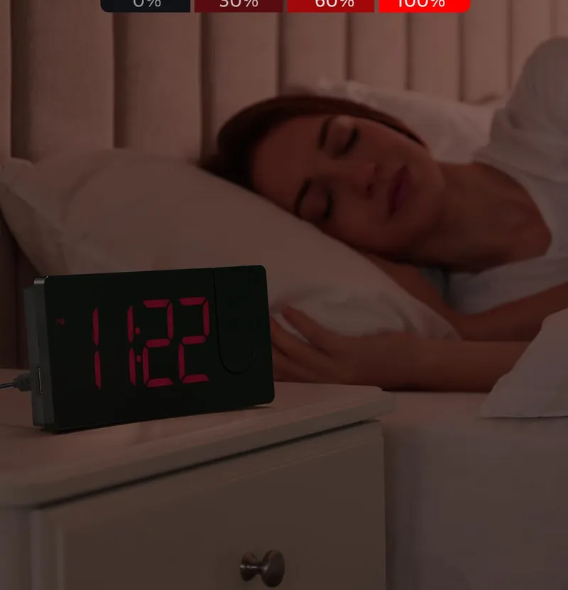 Projection alarm clock with dimmed red digits beside a sleeping woman