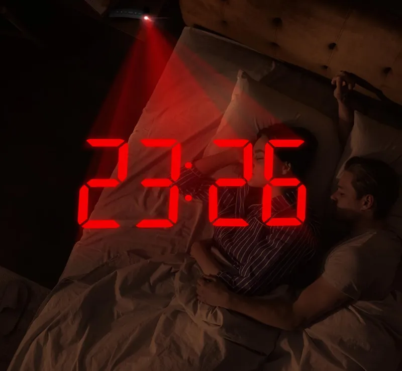 Red projection of the time on a dark bedroom wall